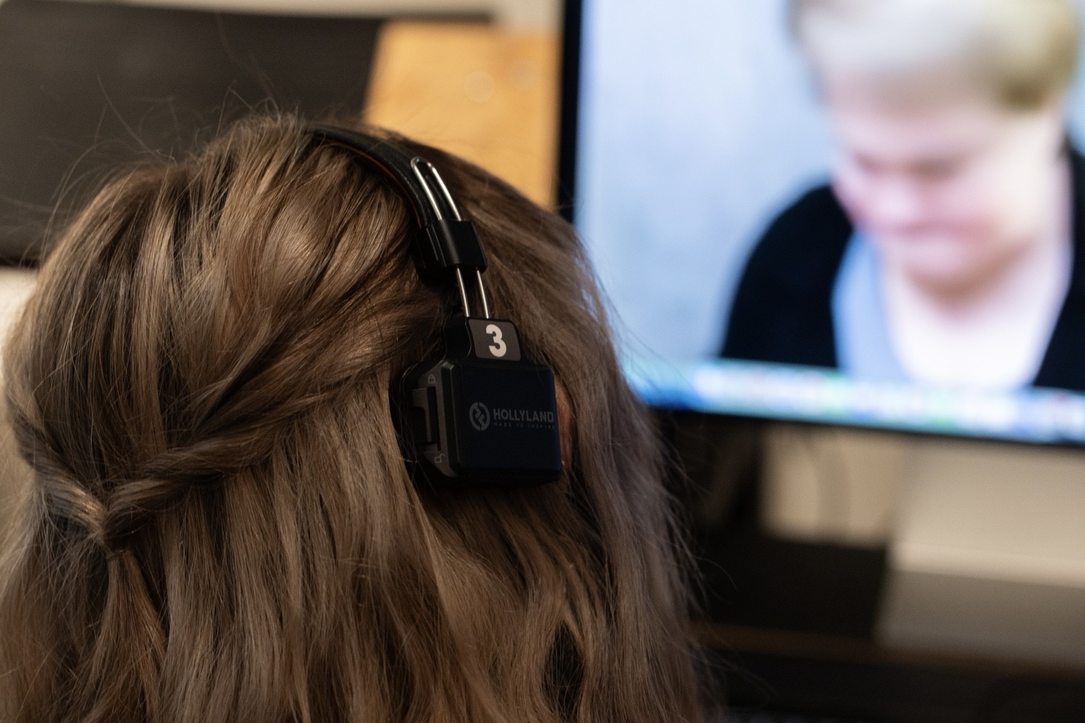 Emma Fuller wearing a production headset in front of a studio monitor